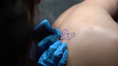 The-tattoo-artist-is-tattooing-Arnold-character-from-Hey-Arnold-cartoon-on-a-man's-back