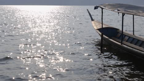 Ein-Altes-Hölzernes-Longtail-Boot,-Das-Auf-Dem-See-Schwimmt