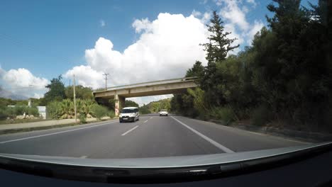 Fluffy-clouds-above-landscape-and-highway-road-of-Crete-island