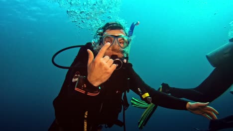 Diver-communicating-with-other-diver-underwater