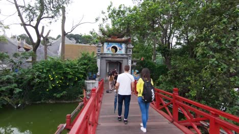 An-ancient-bridge-in-a-Hanoian-Temple-with-a-couple-walking