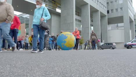 Global-Climate-Strikes-2021-Demonstrators-Walking-In-The-Street-With-Large-Globe-In-Saint-Polten,-Austria