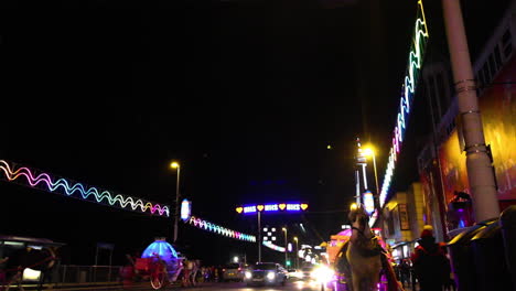 NHS-neon-sign-in-Blackpool,-taken-on-the-night-of-the-illuminations-switch-on-2020-with-neon-horse-and-carriage-rides-on-the-road