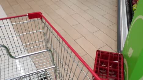 POV-shot-of-an-anonymous-shopper-with-a-cart-checking-the-different-sections-of-the-supermarket