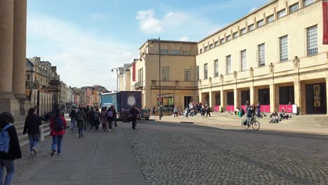 Cobbled-street-view-of-crowds-of-people,-locals-and-tourist,-visiting-the-popular-tourism-destination-of-Oxford-City-in-England-UK