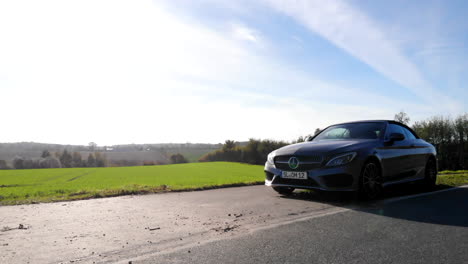 Coche-Convertible-Mercedes-Benz-Clase-C-Gris-Estacionado-Junto-A-Una-Carretera-Rural-En-El-Campo-Alemán,-Girando-De-Frente-A-Derecha