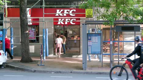 Pedestrians-are-seen-outside-the-Kentucky-Fried-Chicken-restaurant,-the-American-fast-casual-chicken-chain,-in-Madrid,-Spain