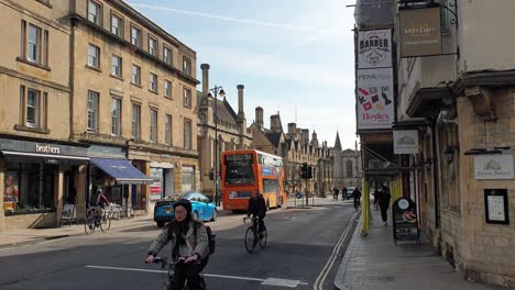 Double-double-bus,-taxis-and-cyclist-on-the-streets-lined-by-heritage-buildings-in-city-centre-of-Oxford,-England-UK