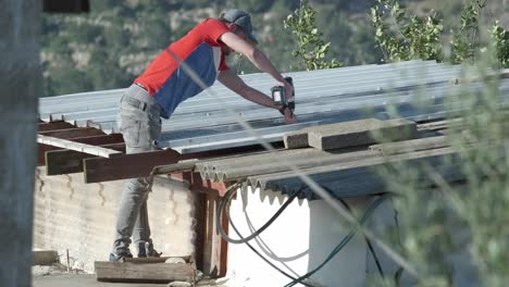 Skilled-construction-worker-on-the-roof-of-a-house-in-Jerusalem-repairs-with-his-professional-drill