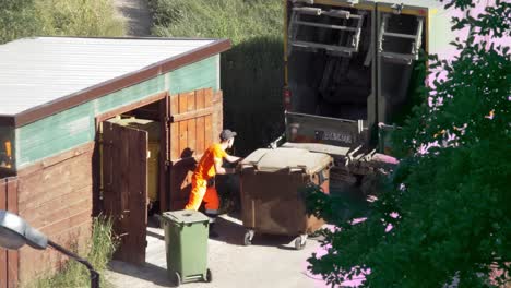 Man-Empties-Trash-Cans-Into-A-Garbage-Truck