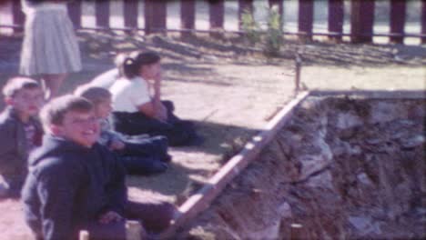 Panning-shot,-bulldozer-transferring-rock-and-soil,-people-gather-on-the-side-to-watch,-truck-passing-by-in-the-background