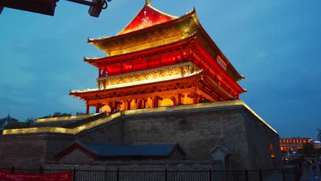 Xian,-China---July-2019-:-Tourists-walking-in-front-of-the-Xian-Bell-Drum-Tower-beautifully-lit-and-illuminated-at-night,-Shaaxi-Province