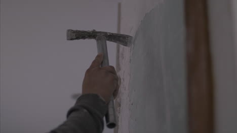 Hombre-Con-Una-Pequeña-Picota-Arreglando-Las-Imperfecciones-De-La-Pared-Antes-De-Pintar,-En-Cámara-Lenta-De-4k