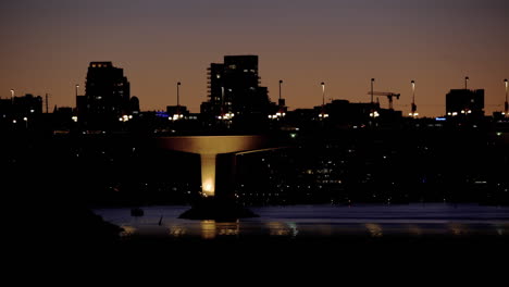 Dusk-shot-city-of-Vancouver-from-a-sea-wall-of-Falls-Creek-bicycles-passing-closeup