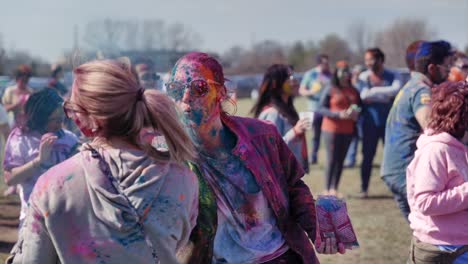 Woman-blowing-colored-powder-at-friend-during-Holi-festival