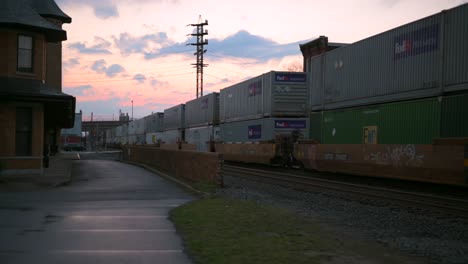 Train-moving-along-tracks-during-sunset