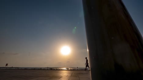 Menschen,-Die-Bei-Sonnenuntergang-Auf-Der-Promenade-Spazieren-Gehen,-Sonnenuntergang-Im-Hintergrund