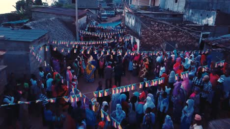 Toma-Aérea-De-Drones-De-Personas-Y-Familias-En-Una-Fiesta-De-Boda-En-Las-Calles-De-Un-Pequeño-Pueblo-Rural-En-Las-Comoras,-África