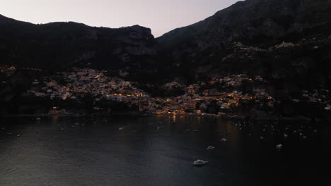 Flying-towards-Positano-in-Amalfi-coast,-Italy-during-dusk