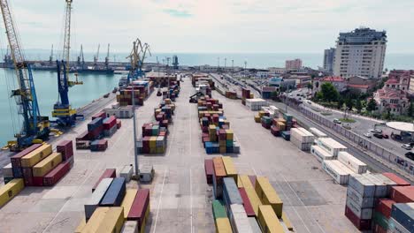 aerial-view-of-a-large-amount-of-shipping-contaniers-on-top-of-one-another-ready-to-be-loaded,-Descending-wide-shot