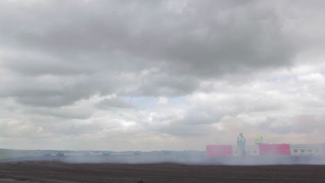 Nissan-280SX-and-Nissan-Skyline-R34-drifting-on-a-drift-track-seen-from-a-low-angle-with-lots-of-smoke-from-the-tyres-and-close-racing