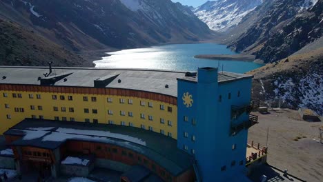 PORTILLO,-CHILE---MAY-15,-2022:-Tilt-up-aerial-view-of-Hotel-Portillo-in-the-Andes-of-Chile,-Laguna-del-Inca-in-the-background-with-snowcapped-mountains