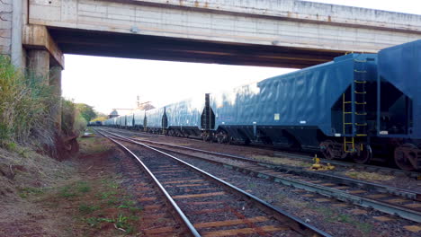 Transport-train-carrying-resources,-outdoor-on-a-gravel-platform-style-railroad,-MRS-Railway-Company-in-inter-modal-Port