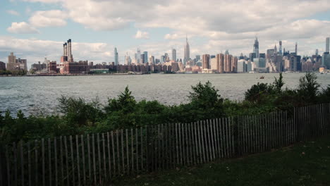 Panorámica-A-Través-Del-Horizonte-De-La-Ciudad-De-Nueva-York-Desde-El-Parque-Estatal-East-River-En-Brooklyn-Mostrando-El-Centro-De-Manhattan