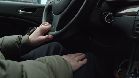 Guy-in-green-rainjacket-is-driving-a-BMW-and-he-moves-his-hand-to-the-music,-Slow-Motion