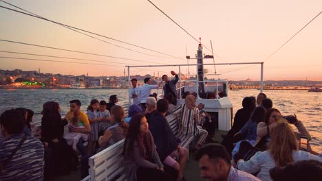 Unidentfied-people-have-Istanbul-boat-tour-with-view-of-bosphorus-and-New-Mosque-at-sunset-in-istanbul,Turkey