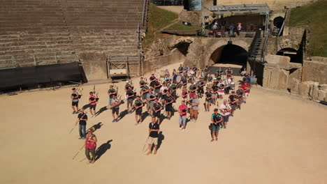 Drone-shot-following-pipes-and-drums-musicians-entering-the-roman-arena-in-Avenches-Switzerland