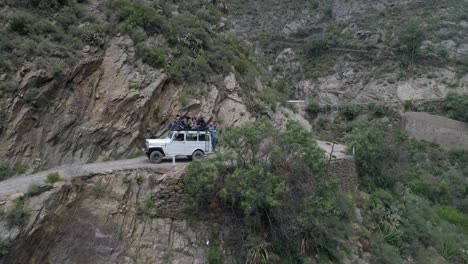 Aerial-shot-of-a-Willis-Jeep-with-tourist-in-a-narrow-road-in-Real-de-Catorce,-San-Luis-Potosi,-Mexico