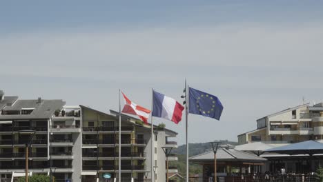 French-flag-waving-in-the-wind-alongside-european-union-at-Savoie-aix-les-bains-region