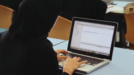 Arab-woman-writing-code-on-laptop.-Handheld-Shot