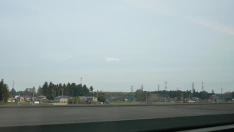 landscape-view-of-the-urban-city-outside-Tokyo-from-inside-the-moving-high-speed-train-shinkansen-train-in-cloudy-weather-sky