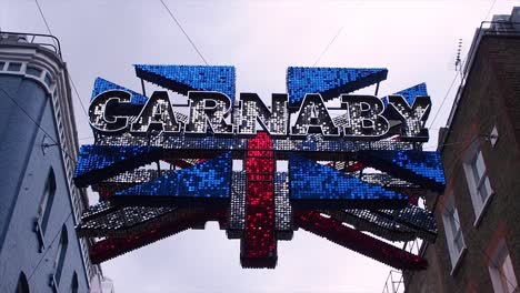 Union-Jack-Flag,-3D-Sign-Decoration-In-Carnaby-Street-In-Soho-In-The-City-Of-Westminster,-Central-London,-United-Kingdom,-Europe