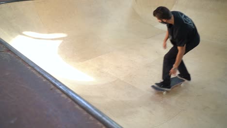 Man-with-mask-driving-up-and-down-the-ramps-in-skateboard-hall