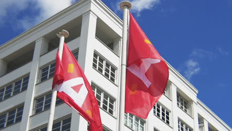 Two-red-Antwerp-flags-waving-in-the-wind-on-a-sunny-day