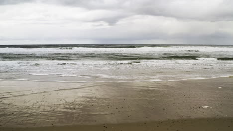 Weite-Aufnahme-Der-Meereswellen-Am-Strand-Entlang-Der-Sandküste-An-Einem-Bewölkten-Tag,-Küste-Von-Neskowin,-Oregon,-USA