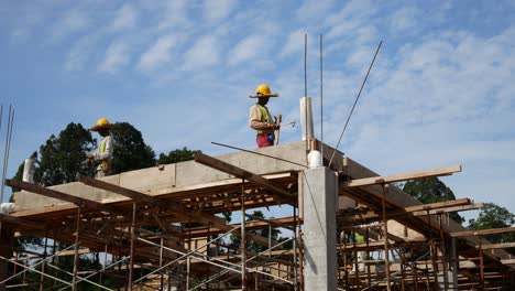 Construction-workers-installing-timber-form-works-and-rain-water-down-pipes-at-the-construction-site