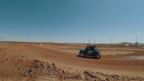 Blue-off-roading-vehicle-racing-on-dirt-track-in-California-City