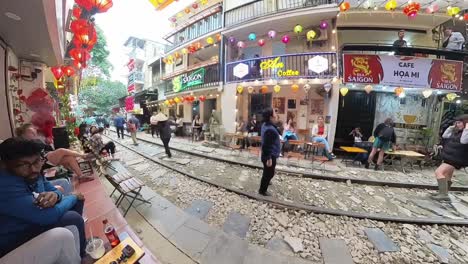 Timelapse-De-Personas-Moviéndose-Cerca-De-Edificios-A-Ambos-Lados-De-Las-Vías-En-La-Calle-Del-Tren-De-Hanoi,-Una-Estrecha-Circunvalación-Del-Tren.