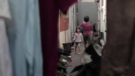 Asian-chinese-looking-girl-walking-in-an-alley,-somewhere-in-south-east-asia,-Jakarta-City