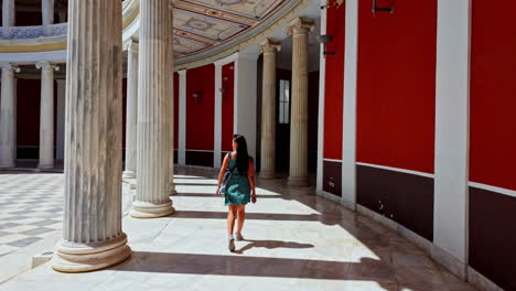 Atractiva-Mujer-Caucásica-Caminando-Por-Un-Patio-Bordeado-De-Pilares-En-Cámara-Lenta