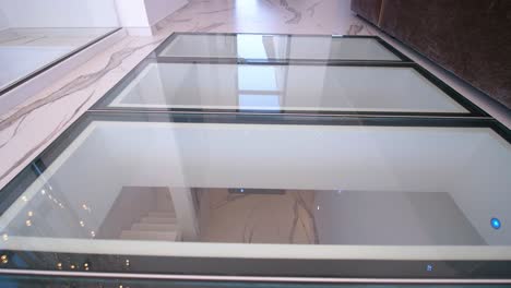 Slow-establishing-shot-of-a-villa-with-a-glass-floor-revealing-the-floor-below