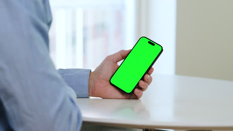 Green-screen-smartphone-template,-left-hand,-man-in-blue-shirt