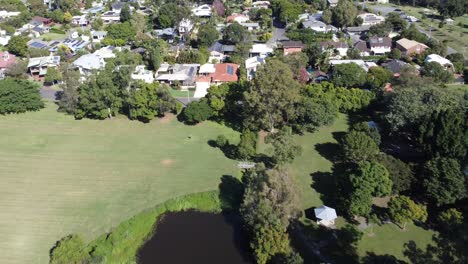 Drohne-Fliegt-über-Einen-Kleinen-See-In-Richtung-Wohngebiet-In-Australien