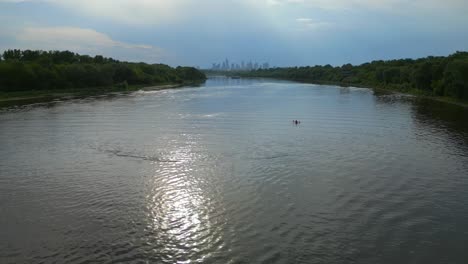 People-kayaking,-water-sports,-Vistula-River,-Warsaw-city-skyline,-aerial