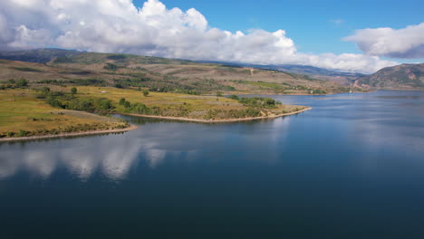 Aerial-View-of-Beautiful-Blue-River-and-Green-Mountain-Water-Reservoir-on-Sunny-Summer-Day