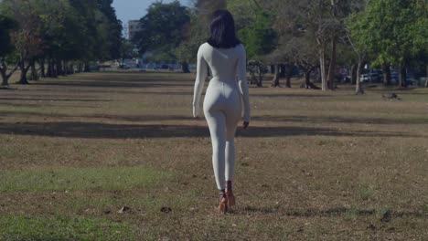 In-a-Caribbean-city,-a-young-girl-in-a-white-bodysuit-poses-with-castles-in-the-background